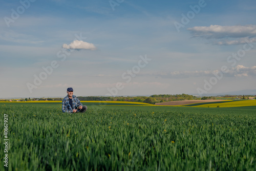 Portrait of Successful Farmer Examining Crops at Agriculture Field. Farmer Looking at Crops Wheat Field