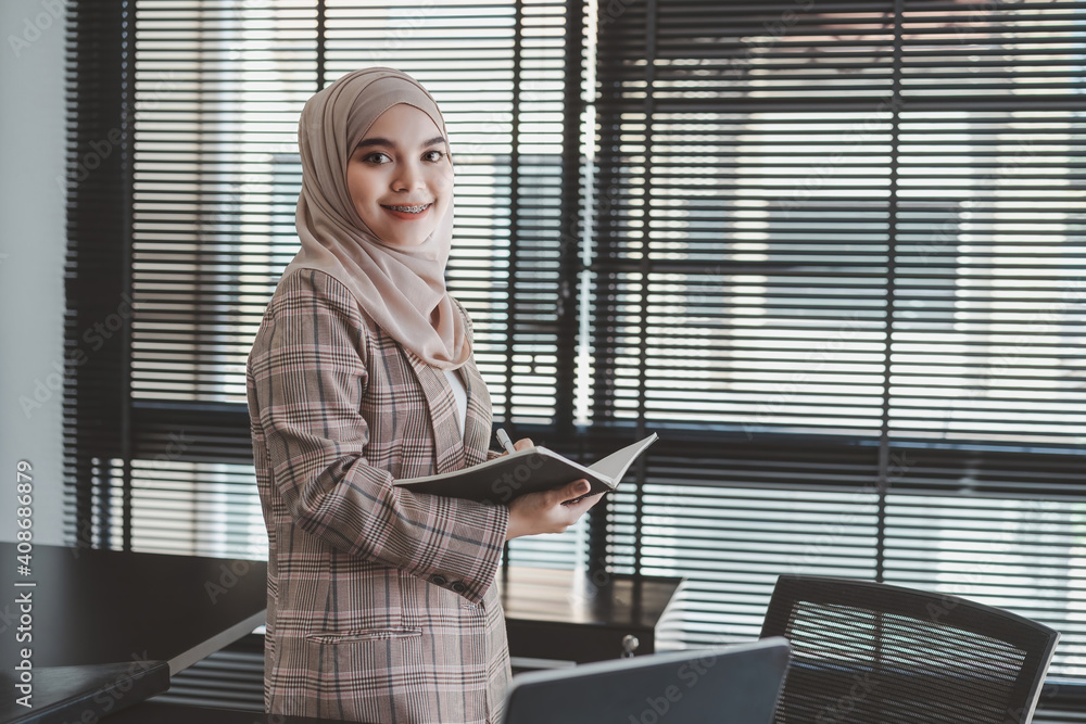 Confident asian muslim business woman brown hijab at modern office. Confident asian muslim business woman brown hijab at modern office.