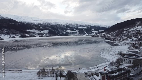 Aerial moving over Voss and showing frozen Vangsvatnet lake close to hotels and road photo