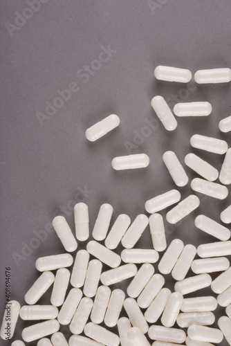 White pills isolated on pastel coloured background. Medication and prescription pills flat lay background. photo