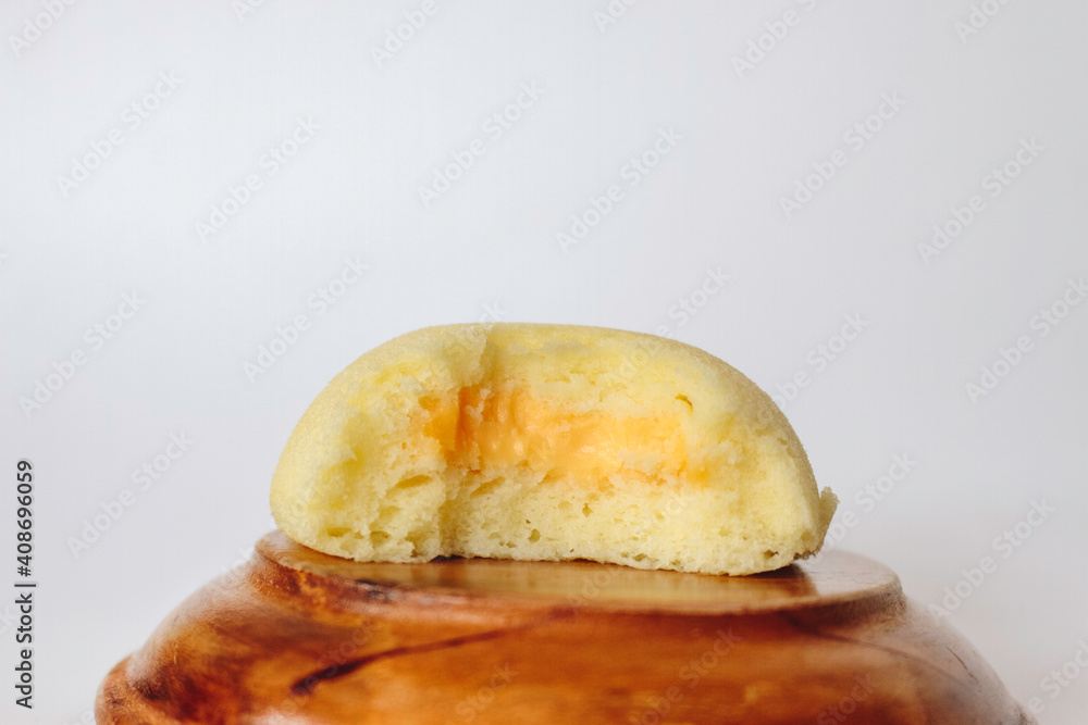 Bakpia Kukus Cake or Steamed Bakpia Cake with Cheese Flavour on wooden plate isolated on white background.