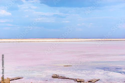 People gathering salt of pink salty Siwash Lake, colored by microalgae, famous for antioxidant properties, enriching water by beta-carotene at sunset