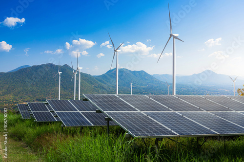 Photovoltaic modules solar power plant with wind turbines against mountains landscape against blue sky with clouds,Alternative energy concept,Clean energy,Green energy.