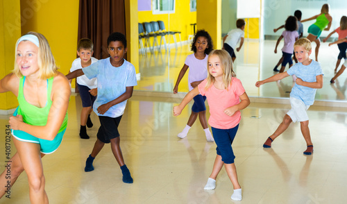 Fototapeta Naklejka Na Ścianę i Meble -  Emotional children performing modern dance in fitness studio. High quality photo