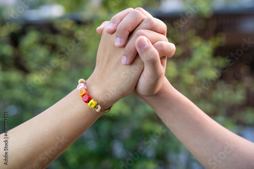 Closeup of couple holding hands, Love word on women Bead bracelet, Valentine concept.