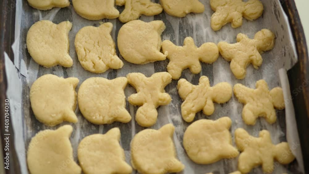 Raw golden shortbread cookies on a baking sheet. dough for baking sugar cookies. it's spinning. rotates Raw golden shortbread cookies on a baking sheet. dough for baking sugar cookies. it's spinning. rotates