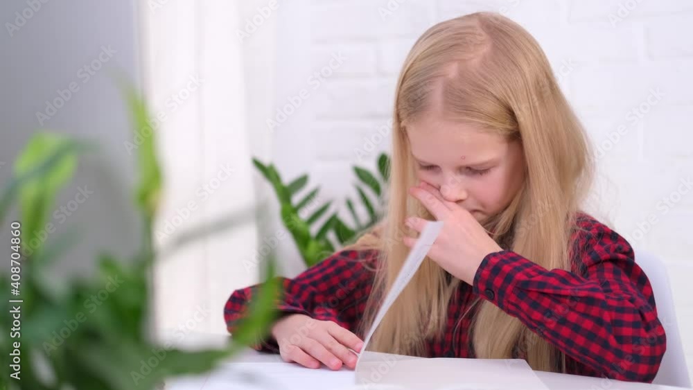 4k Blonde schoolgirl studying at home doing school homework. Training books and notebooks on table. Distance learning online education 4k Blonde schoolgirl studying at home doing school homework. Training books and notebooks on table. Distance learning online education