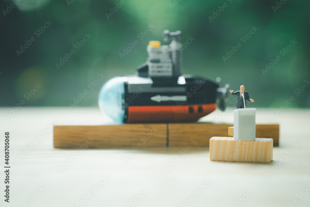 Miniature people of a politician stand on podium during a public speaking of submarine Miniature people of a politician stand on podium during a public speaking of submarine