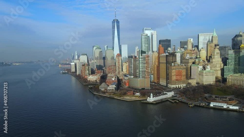 Aerial flying across Hudson River overlooking beautiful downtown Manhattan skyline with stunning One World Trade Center and Battery Park on sunny summer day in New York City, USA.