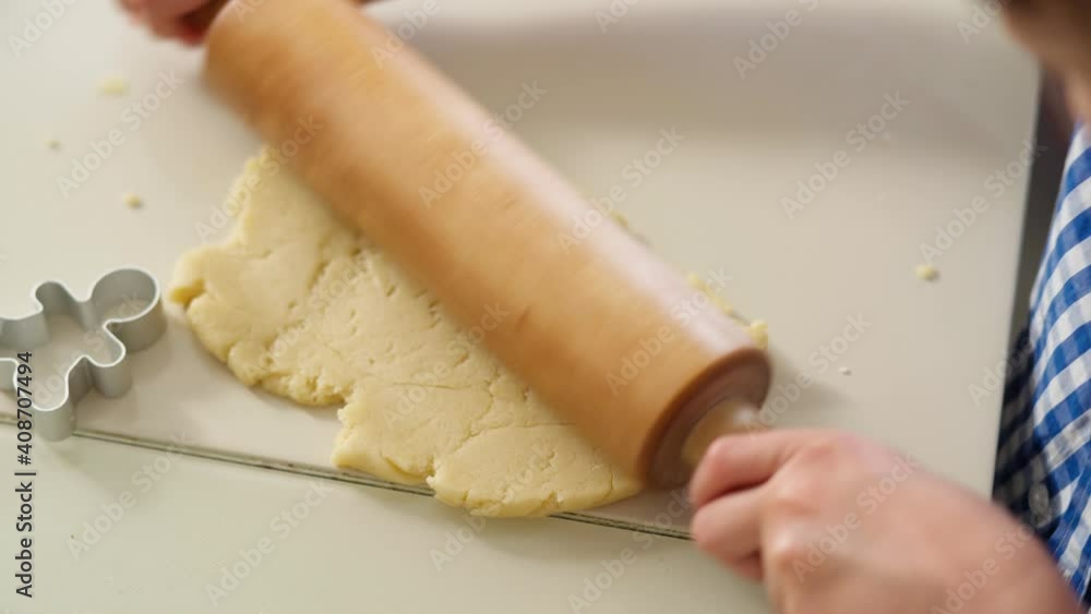 boy rolls out cookie dough with rolling pin Close-up hands boy rolling out shortbread dough into thin pancake, cutting out cookie figures from dough using cookie cutters. 4K Video boy rolls out cookie dough with rolling pin Close-up hands boy rolling out shortbread dough into thin pancake, cutting out cookie figures from dough using cookie cutters. 4K Video