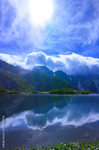 夕方の八方池と太陽と飛行機雲