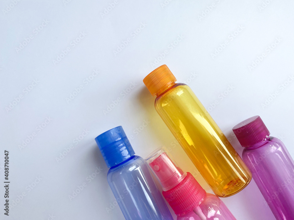 Colorful plastic travel bottles. Small containers for liquids like shower  gel and shampoo. Face and body care products in compact size. Copy space  Stock Photo