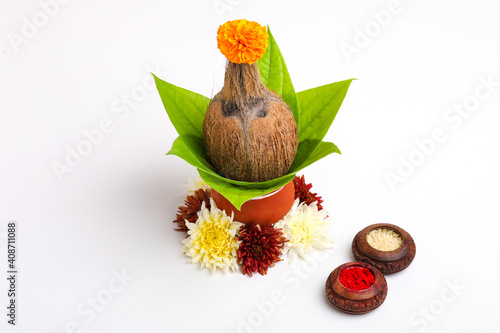 Indian festival akshaya tritiya concept : Decorative coconut with green leaf in clay pot on white background