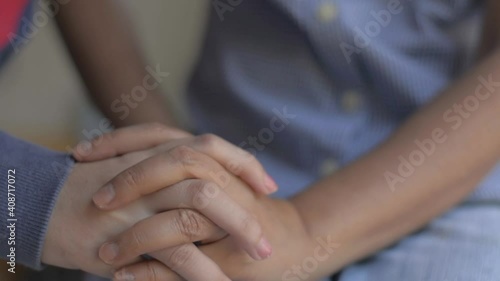 Close-up hands of mother and her daughter joining together and put on mother lap. Expression of love. Caring each other. Slow motion.