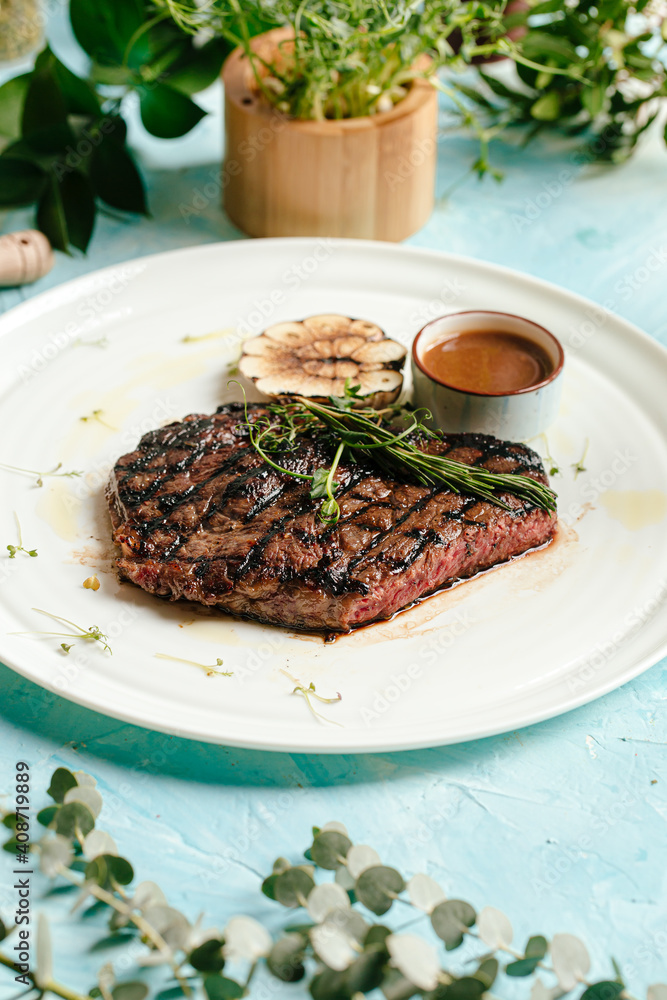 Grilled juicy beef steak medium roast with rosemary and pepper sauce