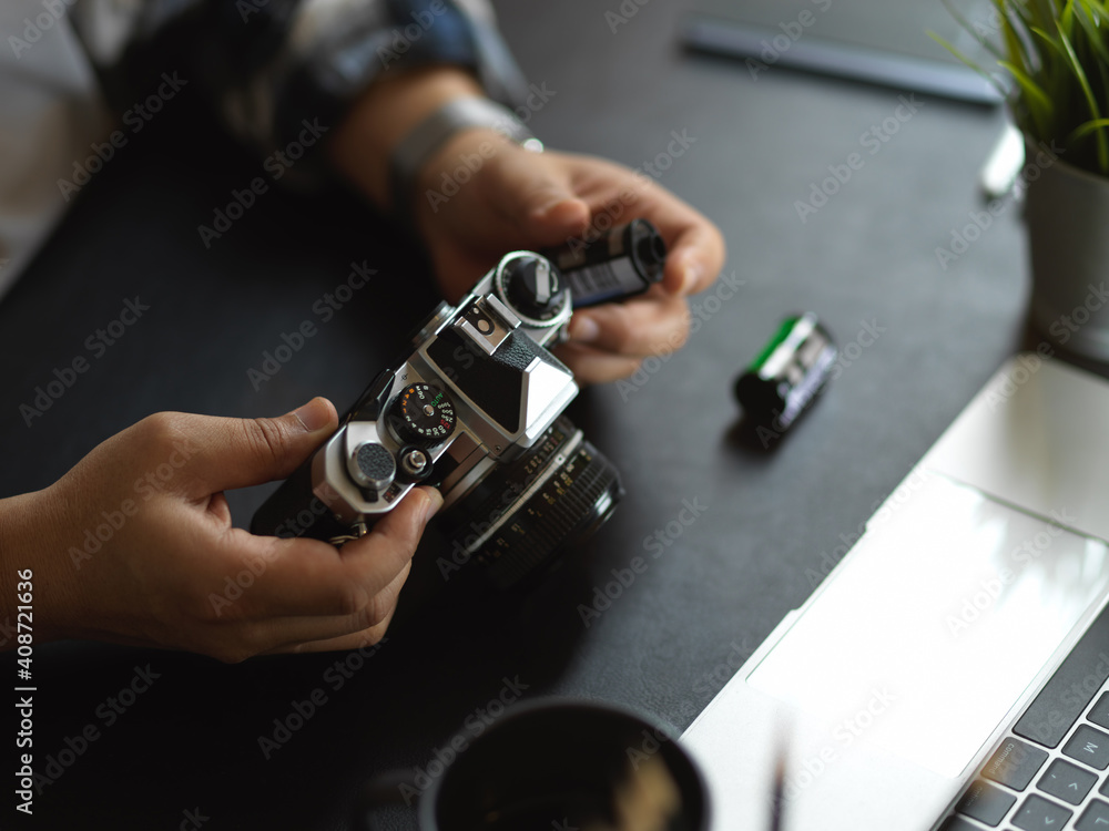 Photographer hands using camera on worktable with supplies in studio Photographer hands using camera on worktable with supplies in studio