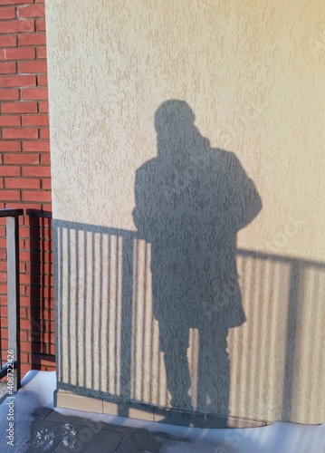  shadow of a man behind a fence