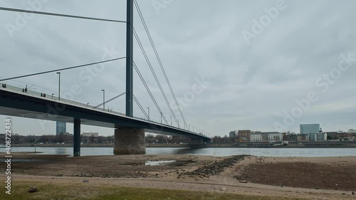 Timelapse of river Rhein bridge in Düsseldirf, Germany with river vessels passing by on a cloudy day