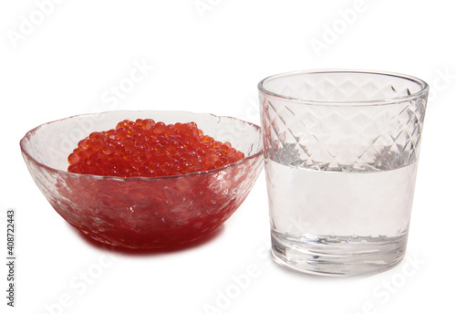 Red caviar lies in glass bowl and vodka. Isolated object on a white background