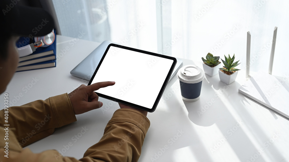 Close up view of young man using digital tablet during working online at home. Close up view of young man using digital tablet during working online at home.