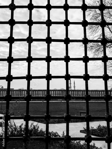 Black bars and sky in historical building. Feelings of imprisonment, confinement and bondage. Longing for freedom.