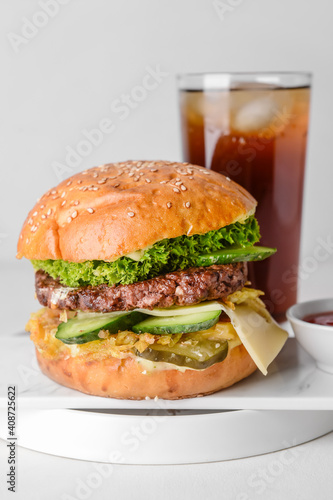 Tasty burger, sauce and cola drink on table