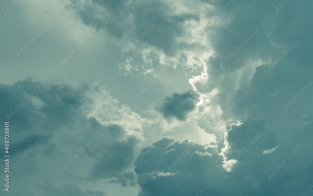 Gray sky and fluffy clouds with sunlight. Cloudy sky. Hope in darkness day. Overcast sky. Background for depressed and sad. Sad and moody sky. Nature background. Cloudscape. Sunlight behind clouds.