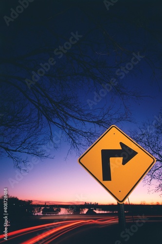 Neon streak of traffic and a sign with right directional arrow at roadside near a lake, White Rock Lake, Dallas, Texas, USA photo