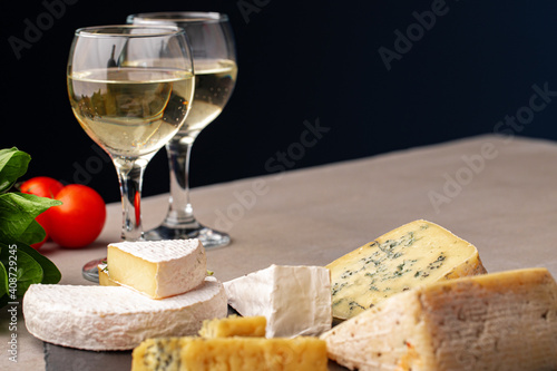 Different types of cheese and wine on gray table
