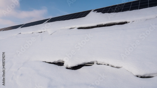 A layer of snow on the panels of a solar power plant. Green energy problems and weather dependence