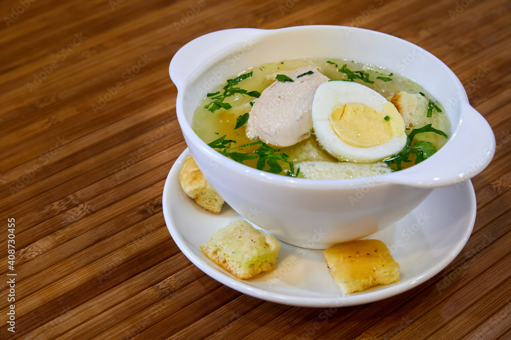 Broth with chicken fillet, egg, croutons and herbs. Close-up, selective focus Broth with chicken fillet, egg, croutons and herbs. Close-up, selective focus