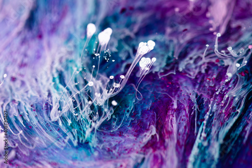 Epoxy resin texture with blue, purple and white colors. Liquid backdrop with splashes and swirls. Abstract frozen texture with alcohol inks. Vibrant pigments mixes on macrophotography wallpaper