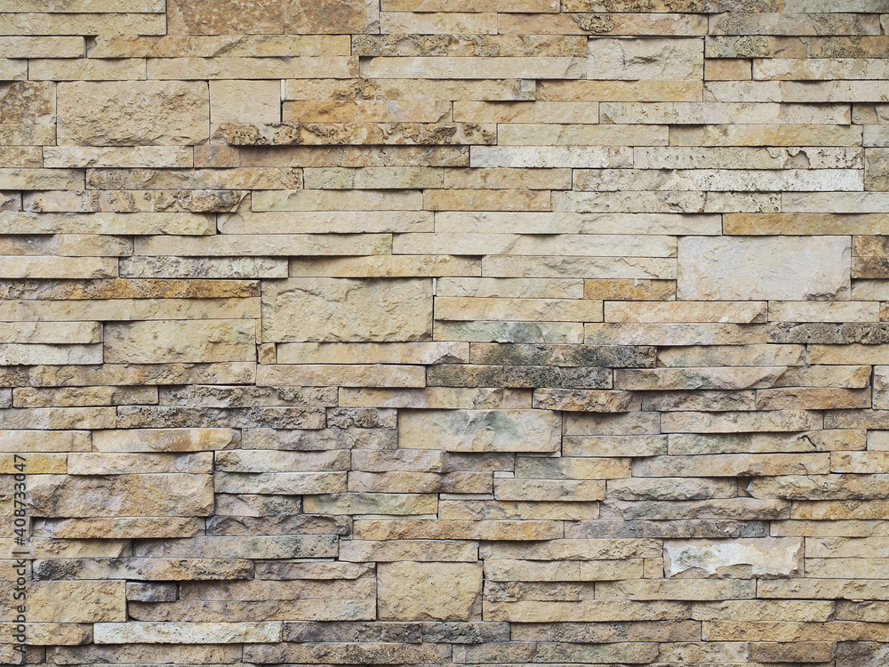 Wall with decorative beige embossed cladding of narrow granite tiles with gray spots. Not seamless texture Wall with decorative beige embossed cladding of narrow granite tiles with gray spots. Not seamless texture