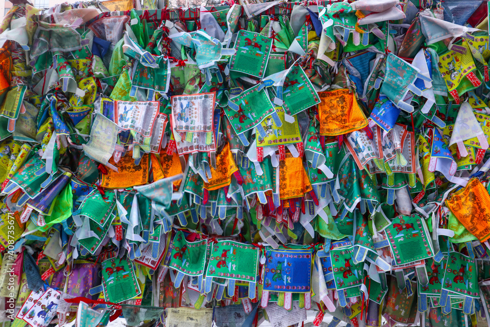 Obraz premium Bright prayer flags with sacred texts in Buddhist temple in St. Petersburg, Russia. This beautiful religious building (The Datsan Gunzechoinei) is located not far from Yelagin Island.