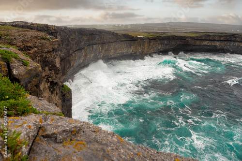 Atlantic ocean and cliff of Inishmore, Aran islands, county Galway, Ireland. Cloudy day, Nobody. Travel and explore nature concept. Powerful wave hits stone coast line. © mark_gusev