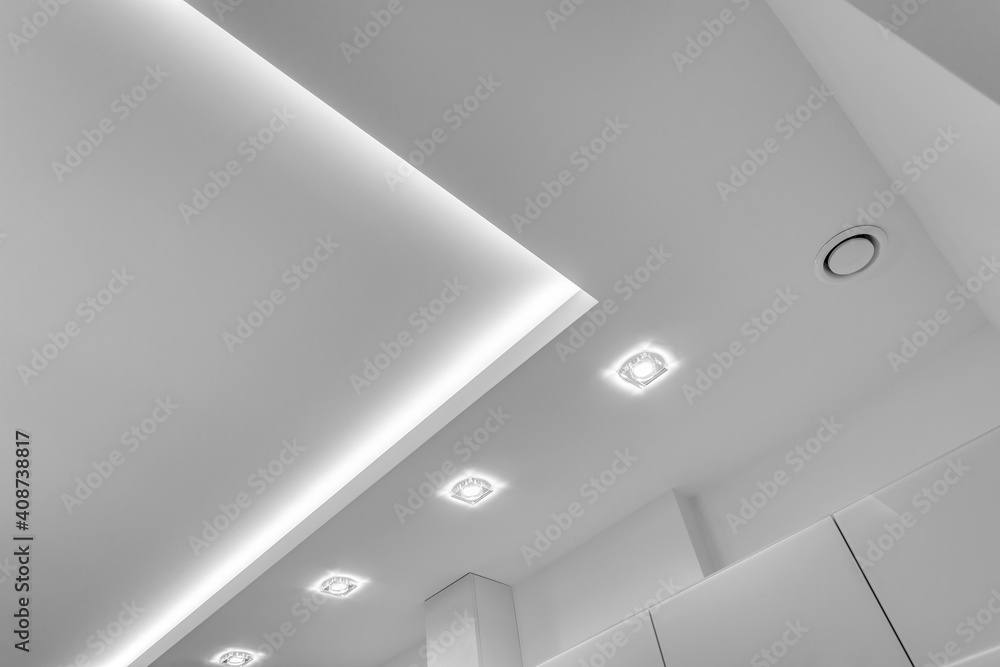 suspended ceiling with halogen spots lamps and drywall construction in empty room in apartment or house. Stretch ceiling white and complex shape. - obrazy, fototapety, plakaty 