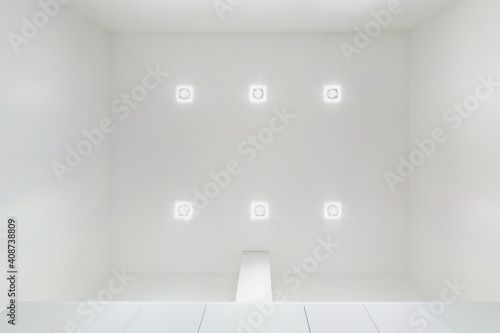 suspended ceiling with halogen spots lamps and drywall construction in empty room in apartment or house. Stretch ceiling white and complex shape.