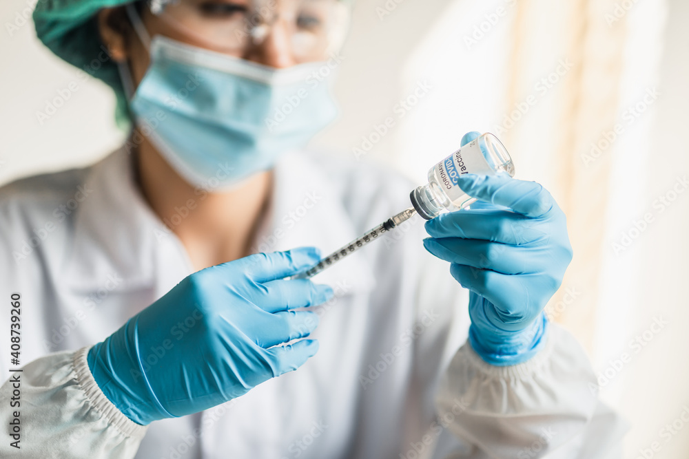 close up, doctor or scientists filling syringe with trial vaccine coronavirus(COVID-19) in laboratory room, concept for research and development of a vaccine against pathogens. close up, doctor or scientists filling syringe with trial vaccine coronavirus(COVID-19) in laboratory room, concept for research and development of a vaccine against pathogens.