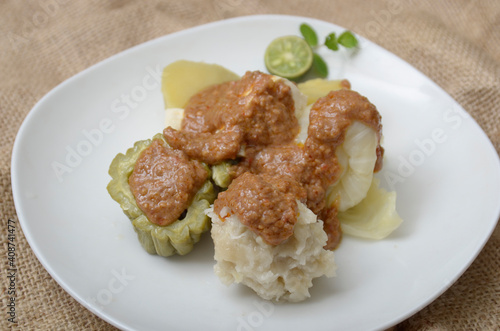 Siomay is an Indonesian steamed fish dumpling with vegetables served in peanut sauce. Somay serve in plate with cabbage, bitter melon, tofu, and potatoes