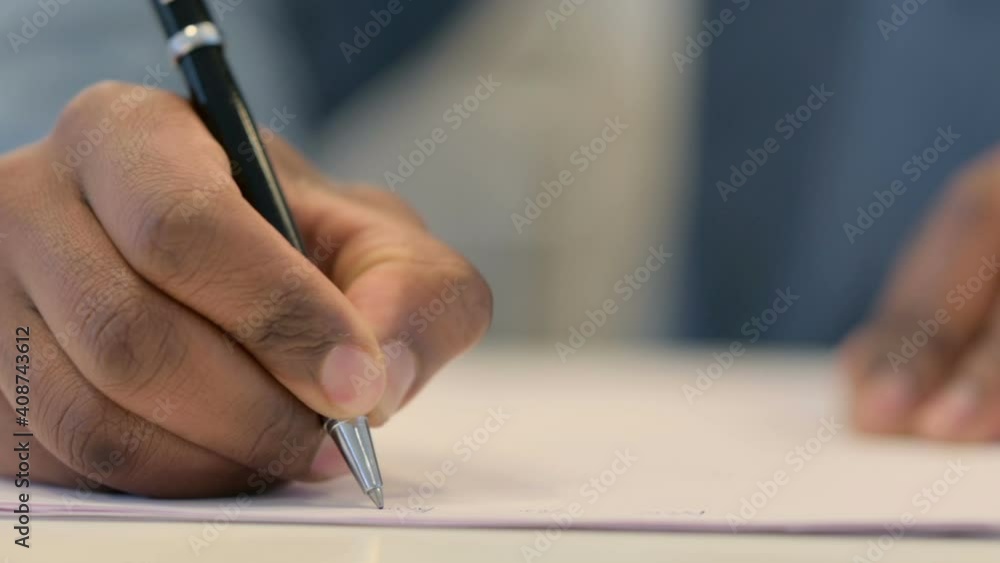 Close Up of African Man Writing on Paper