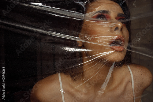Fotografi Photo portrait of brunette woman wearing make-up breathing behind transparent ce