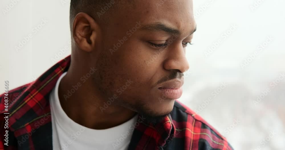 Thoughtful african american man looking out through window Thoughtful african american man looking out through window
