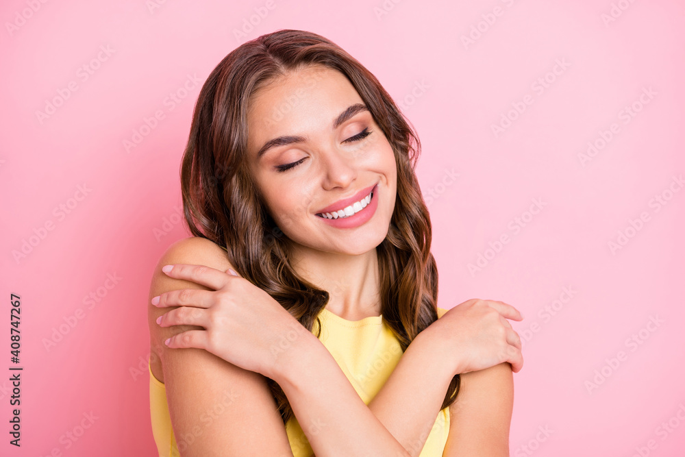 Photo of charming lady closed eyes toothy smile hug shoulder imagine isolated on pastel pink color background Photo of charming lady closed eyes toothy smile hug shoulder imagine isolated on pastel pink color background