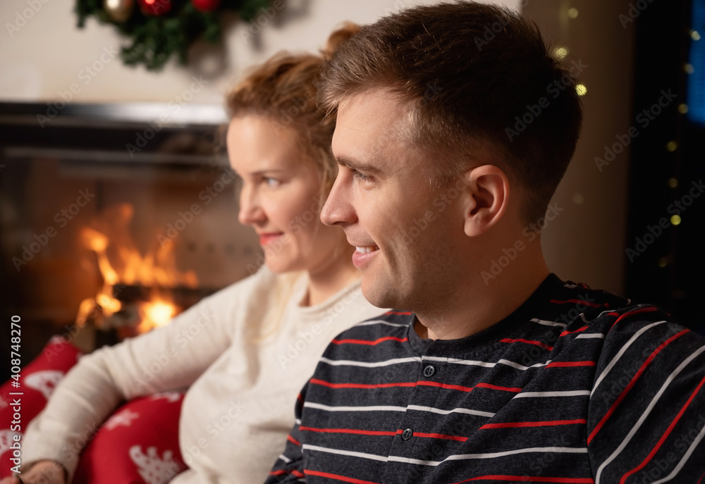 Fototapeta premium Christmas Couple at home by the fireplace