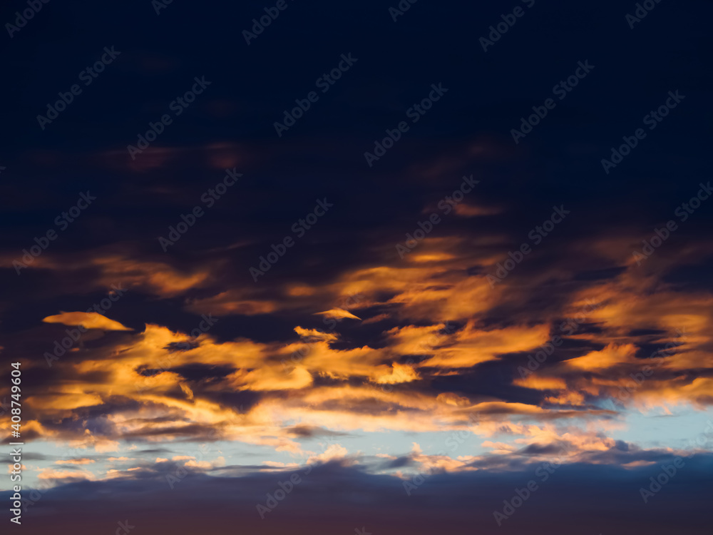 Fantastic sunset with bright red and gold futuristic clouds at the sky.