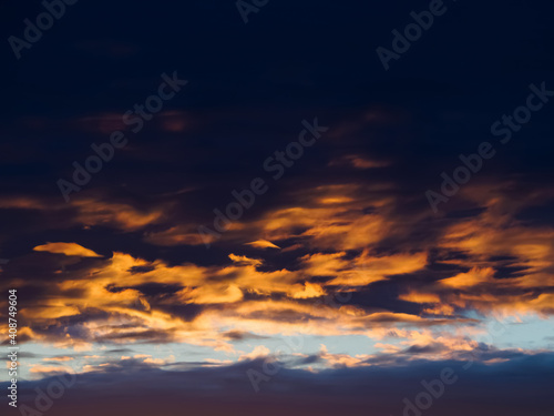 Fantastic sunset with bright red and gold futuristic clouds at the sky.