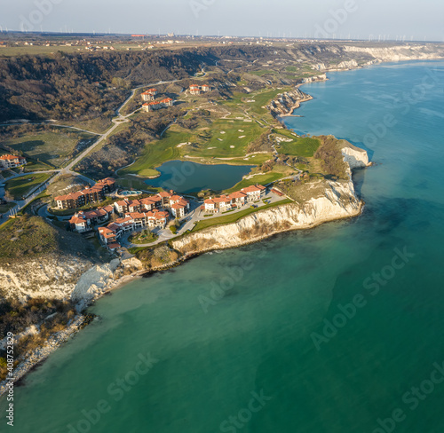 Panoramic view of picturesque landscape with green hills, golf fields and buildings near the rocky coastline of the Black sea, Thracian Cliffs golf and beach resort, Bulgaria photo