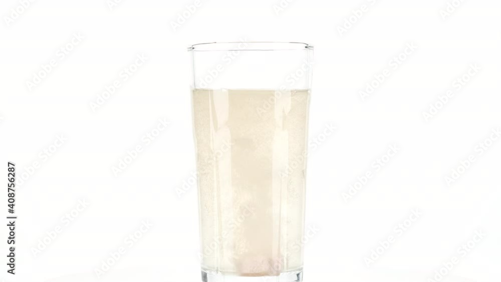 Vitamin C pill dissolving In a Glass of Water, isolated on white background Vitamin C pill dissolving In a Glass of Water, isolated on white background