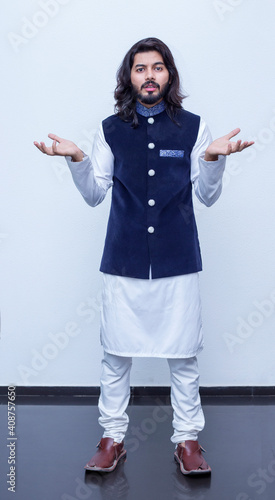 Pakistani Boy standing at studio on white background showing questioning expression. photo