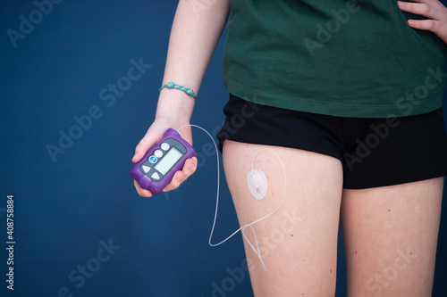 Detail of a hand holding an insulin pump - focus on insulin pump photo